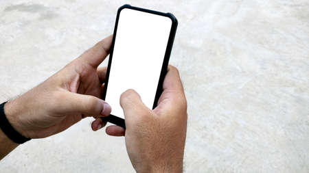 A man holding smartphone with blank screen on white background, closeup of hand. Space for textの写真素材