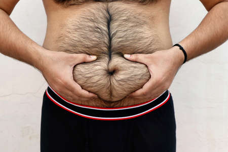 A portrait of a asian fat man show out his body and big belly. Concept of Obesityの写真素材