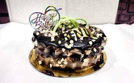 A tasty decorated Birthday Chocolate Cake with Cream and Nuts on the tableの写真素材