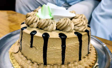 A tasty decorated Birthday Chocolate Cake with Cream and Nuts on the tableの写真素材