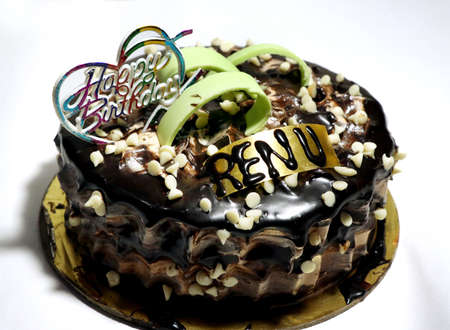 A tasty decorated Birthday Chocolate Cake with Cream and Nuts on the tableの写真素材