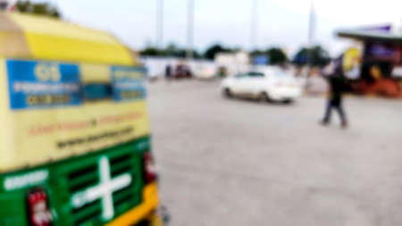 A Blur texture background for design. Out of focus views of city streets on a sunny summer day. Buildings and roads, sky and trees, cars and people.の写真素材