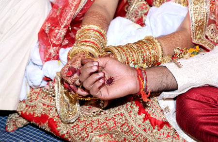 The bride and groom holding hands for traditional Hindu marriageの写真素材