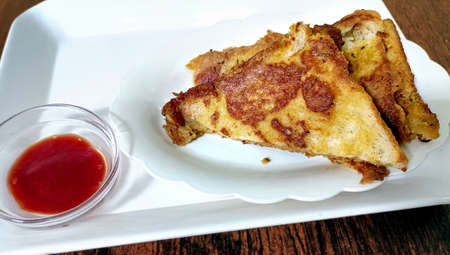 A toasted bread sandwiches with potato stuffing with tomato souce on white plate. Selective focusの写真素材