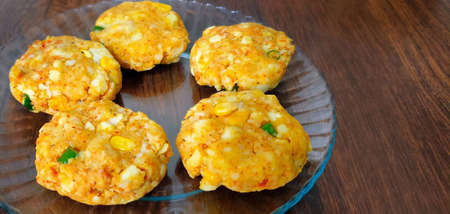 Kabuli chana tikkis, or chickpea patties, a healthy, vegetarian, delicious, and Indian food on a glass plate on wooden tableの写真素材