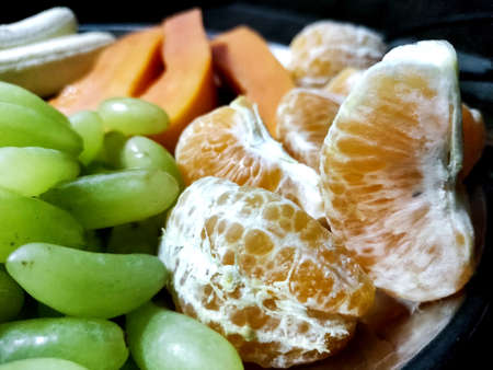 A Plate with different fruits on kitchen tableの写真素材