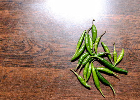 A Top view of Green chili peppers on old wooden table at the kitchen with copy spaceの写真素材