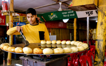 New Delhi, India, December 2 2021: A Man making Aloo tikki (fried potato cutlets), food stall india street food.Selective focusのeditorial素材