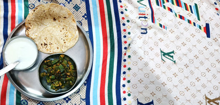 An Indian Cuisine Bhindi or okra curry and Roti or chapati with curd served in a plate. selective...