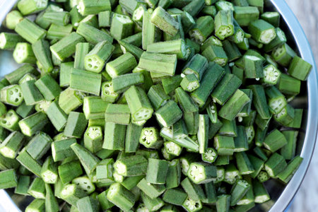 Freshly chopped okra (ladyfinger/bhindi) in a stainless steel plate. Ideal for use in cooking blogs, food preparation concepts, or kitchen stock imageryの写真素材