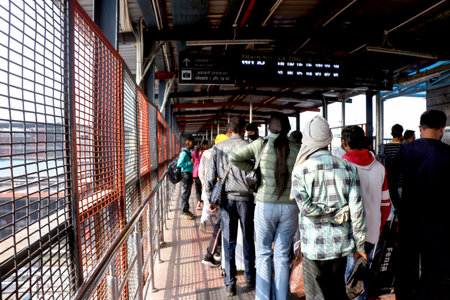 A group of passengers walking along a railway foot overbridge at an Indian train stationの写真素材