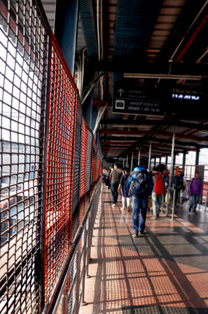A group of passengers walking along a railway foot overbridge at an Indian train stationの写真素材