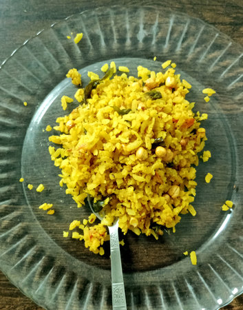 A plate of freshly prepared poha, a popular Indian breakfast dish made with flattened rice, onions, tomatoes, curry leaves, and spicesの写真素材