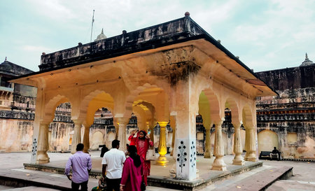 Jaipur, Rajasthan, India, 29 October 2025: Visitors exploring a decorative pavilion with arched columns inside Amber Fort, showcasing intricate Rajput architecture in Jaipur, Rajasthan.のeditorial素材