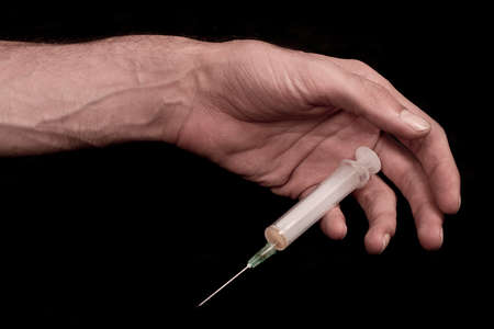 End of drug use. Dead drug addict. Syringe in hand.  の写真素材