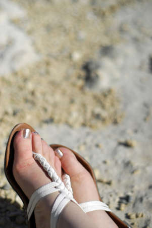womens feet in sandles by beachの写真素材