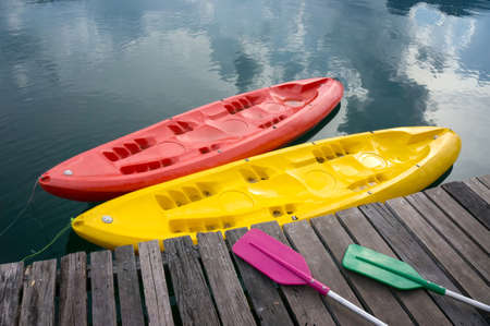 a pair of colorful canoes docked on a lakeの写真素材
