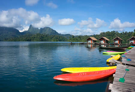 Canoes docked on a lake with houses in the backgroundのeditorial素材