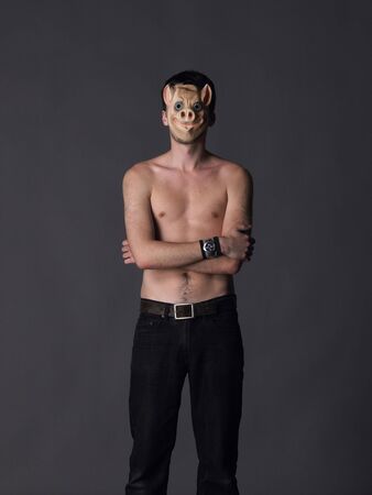 A topless man wears a pig maskの写真素材