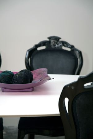 black chairs sit besides a white table with decorations onの写真素材