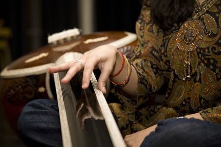 An Indian Musican plucks a string on a Tablaの写真素材