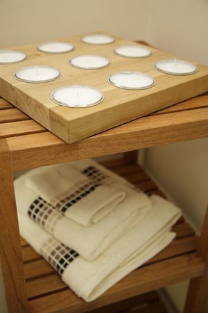 A room with bathtowels and cnadles on a rackの写真素材