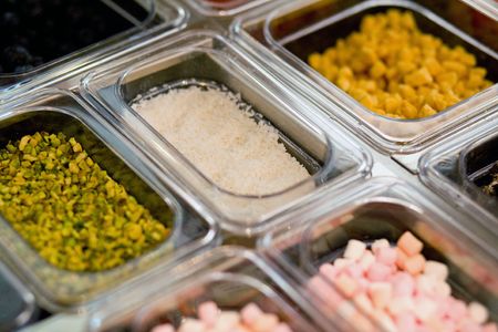 A close up of the selections available in a frozen yogurt shopの写真素材