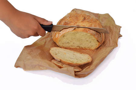 Bread cut by knife on paperbag, isolated on white