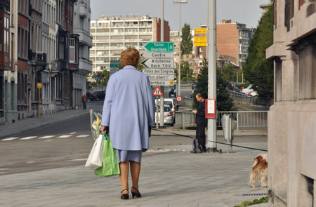 Liege, Belgium - August 2011 - Woman walking her dog down the streets of Liegeのeditorial素材