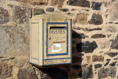 BRITTANY, FRANCE - JULY 2014: old yellow French postbox hanging on a wall in Brittany, Franceのeditorial素材