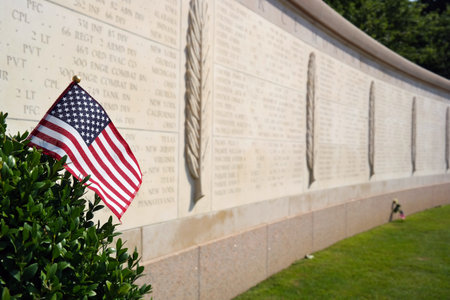 An American flag in front of Walls of the Missing at The Normandy American Cemetery in Colleville-sur-Mer, Franceのeditorial素材