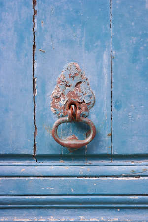 Old metal door knocker on blue painted wooden doorの写真素材