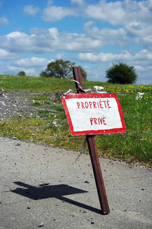 Pole with hand painted sign indicates in French: proprit private, Means private property.の写真素材
