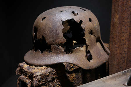 A rusty German World War II military helmet Pierced with bullets, remnant of the Battle of the Bulge, found in the ardennes.の写真素材