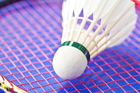 Badminton rackets and shuttlecock isolated on blue backgroundの写真素材