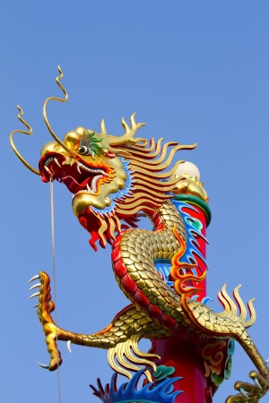 Golden dragon statue on red pillar in Chinese templeの写真素材