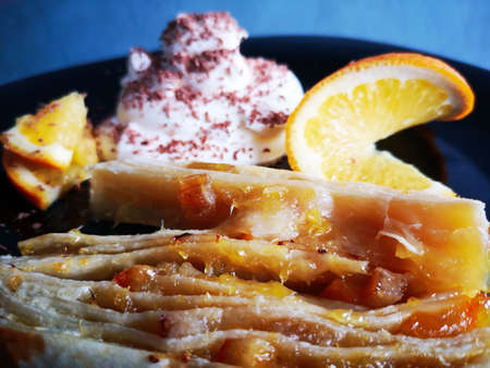 Delicious orange jam puff served with whipped cream, orange slices and grated chocolateの写真素材