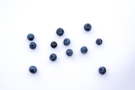 Flat lay composition with juicy, fresh blueberries. Isolated ecological ripe sweet bilberry fruits on white background. Copy Space. Top view of healthy organic summer vegetarian dessert food for dietの写真素材