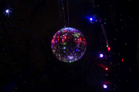 Mirrored Disco Ball and bright beams at the night party. Party attribute reflects Lazer lights. Abstract background with defocused rays. Night club atmosphere. Installation at Vilnius light festivalの写真素材