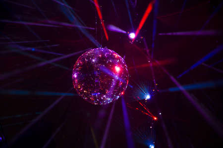 Mirrored Disco Ball and bright beams at the night party. Party attribute reflects Lazer lights....