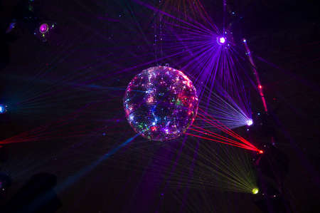 Mirrored Disco Ball and bright beams at the night party. Party attribute reflects Lazer lights....