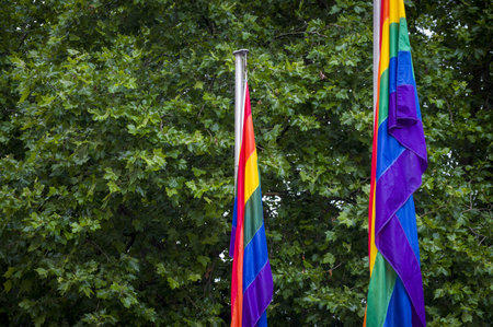 Close-Up rainbow gay pride flag outside on a street. Symbol of the Lesbian Bisexual Transgender LGBT community waving in wind against cloudy sky. Social movement for freedom and equliaty. Copy Spaceの写真素材