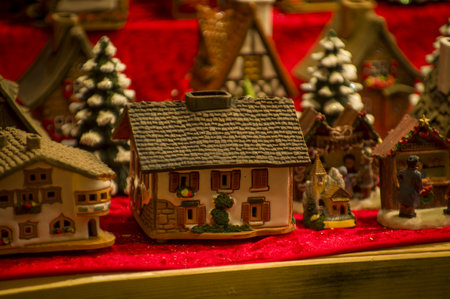 Advent Bazaar Stalls with glass, wooden, ceramic christmas souvenirs in a shop. Close up of festive decorations for tree in winter street night market during new year's holiday. Illuminated fair kioskの写真素材