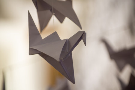 Japanese folded Origami cranes hanging on with strings. Hundreds handmade paper birds isolated with copy space. 1000 thousand crane tsuru sculpture topic. Symbol of peace, faith, health, wishes, hopeの写真素材