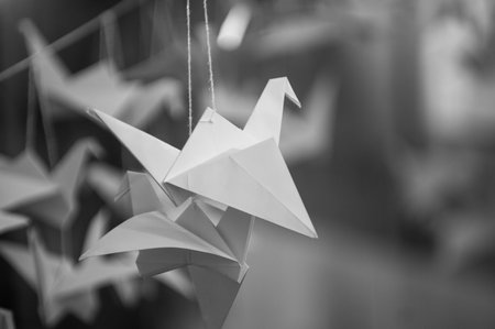 Japanese folded Origami cranes hanging on with strings. Hundreds handmade paper birds isolated with copy space. 1000 thousand crane tsuru sculpture topic. Symbol of peace, faith, health, wishes, hopeの写真素材