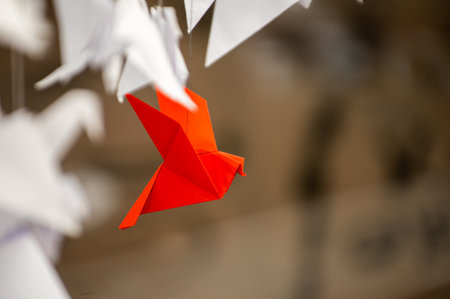 Japanese folded Origami cranes hanging on with strings. Hundreds handmade paper birds isolated with copy space. 1000 thousand crane tsuru sculpture topic. Symbol of peace, faith, health, wishes, hopeの写真素材