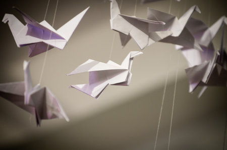 Japanese folded Origami cranes hanging on with strings. Hundreds handmade paper birds isolated with copy space. 1000 thousand crane tsuru sculpture topic. Symbol of peace, faith, health, wishes, hopeの写真素材