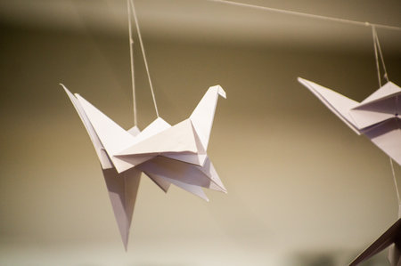 Japanese folded Origami cranes hanging on with strings. Hundreds handmade paper birds isolated with copy space. 1000 thousand crane tsuru sculpture topic. Symbol of peace, faith, health, wishes, hopeの写真素材