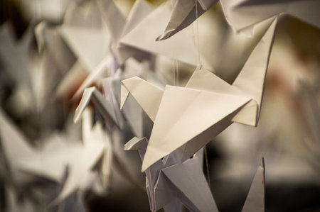 Japanese folded Origami cranes hanging on with strings. Hundreds handmade paper birds isolated with copy space. 1000 thousand crane tsuru sculpture topic. Symbol of peace, faith, health, wishes, hopeの写真素材