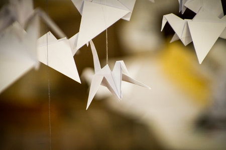 Japanese folded Origami cranes hanging on with strings. Hundreds handmade paper birds isolated with copy space. 1000 thousand crane tsuru sculpture topic. Symbol of peace, faith, health, wishes, hopeの写真素材